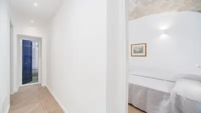a white bedroom with a bed and a window at groundfloor wonderfull apartment in Rome