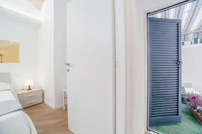 a bedroom with a sliding door with a window at groundfloor wonderfull apartment in Rome