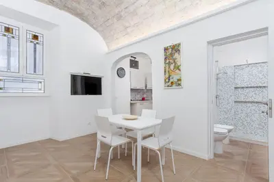 a white dining room with a white table and chairs at groundfloor wonderfull apartment in Rome