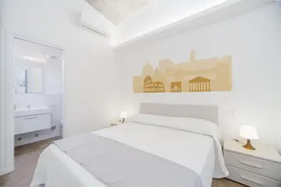 a white bedroom with a bed and a sink at groundfloor wonderfull apartment in Rome