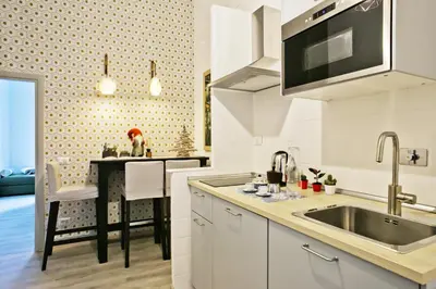 a white kitchen with a sink and a table at A Casa Lamperini 59 in Rome