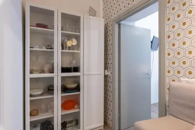 a white cabinet with dishes in it in a room at A Casa Lamperini 59 in Rome