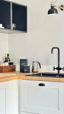 a kitchen with white cabinets and a sink at Colosseo Apartment 23 in Rome
