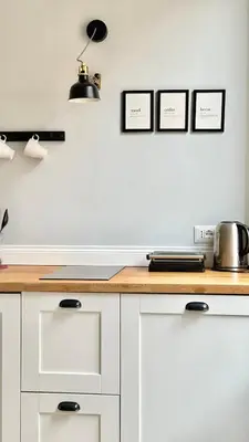 a kitchen with white cabinets and a wooden counter top at Colosseo Apartment 23 in Rome