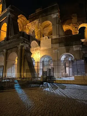 a building with a fence in front of it at night at Colosseo Apartment 23 in Rome