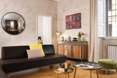 a living room with a black couch and a mirror at Piazza del Popolo Boutique Home in Rome