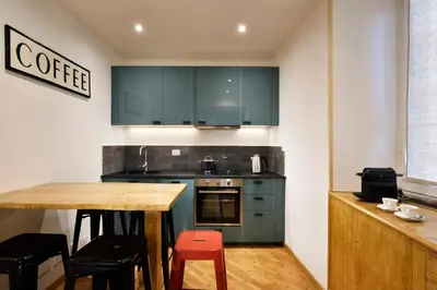 a kitchen with green cabinets and a wooden table at Piazza del Popolo Boutique Home in Rome