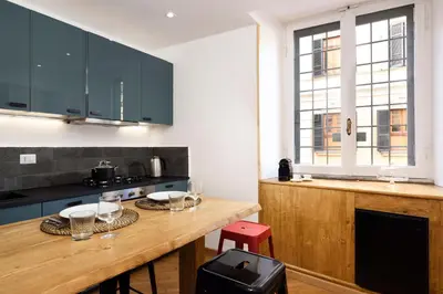 a kitchen with a wooden table and a counter top at Piazza del Popolo Boutique Home in Rome