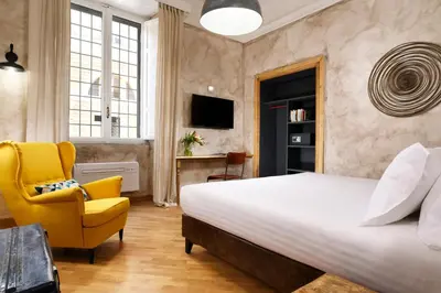 a bedroom with a bed and a yellow chair at Piazza del Popolo Boutique Home in Rome