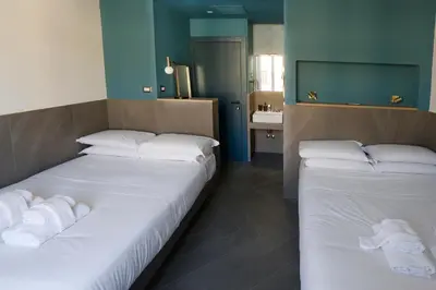two twin beds in a room with a bathroom at Ottaviano Smart Rooms in Rome