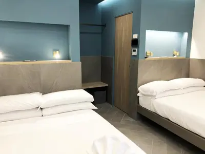 two beds in a room with blue walls at Ottaviano Smart Rooms in Rome