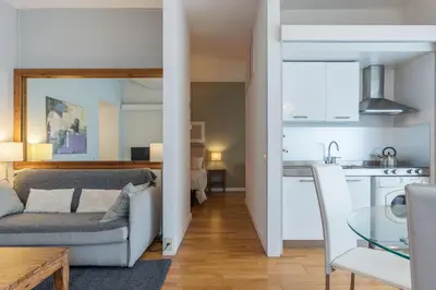 a living room and kitchen with a couch and a table at GuestHost - Sant'Angelo Modern Apartment in Rome