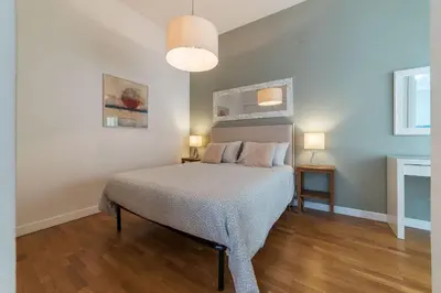 a bedroom with a bed and two lamps on two tables at GuestHost - Sant'Angelo Modern Apartment in Rome
