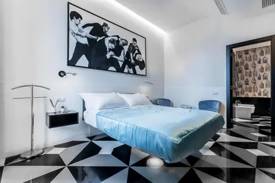 a bedroom with a bed and a black and white checkered floor at V-Accommodation IV Fontane in Rome