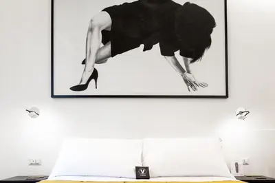 a picture hanging on a wall above a bed at V-Accommodation IV Fontane in Rome