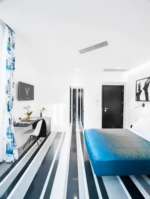 a bedroom with a blue bed and striped flooring at V-Accommodation IV Fontane in Rome