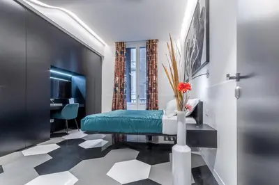 a room with a bed and a desk and a television at V-Accommodation IV Fontane in Rome