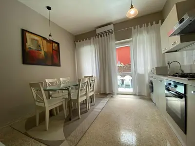 a kitchen and dining room with a table and chairs at èROMA - RE DI ROMA Apartment in Rome