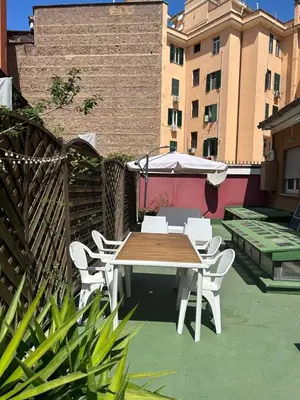 a table and chairs and an umbrella on a patio at èROMA - RE DI ROMA Apartment in Rome