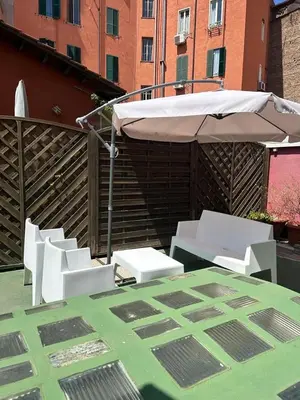 a group of white chairs and an umbrella on a patio at èROMA - RE DI ROMA Apartment in Rome