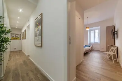 a hallway with white walls and wood floors and a bedroom at Roman Station House in Rome