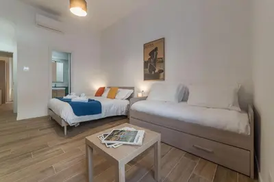 a hotel room with two beds and a table at Roman Station House in Rome