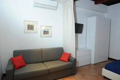a living room with a couch with two red pillows at RELAIS CAVOUR 133 in Rome