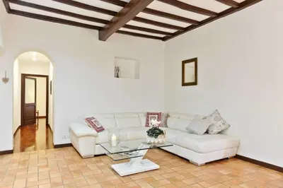 a living room with a white couch and a glass table at La Finestra su Trastevere - Appartamento 100 mq Centrale, Luminoso, Spazioso in Rome