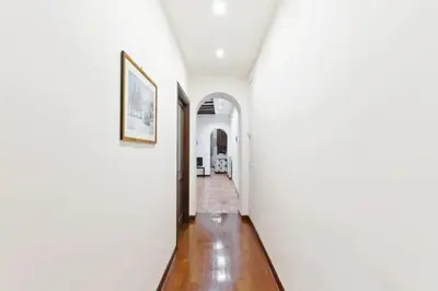 a hallway of a house with white walls and wood floors at La Finestra su Trastevere - Appartamento 100 mq Centrale, Luminoso, Spazioso in Rome