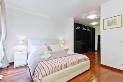 a white bedroom with a bed with two towels on it at La Finestra su Trastevere - Appartamento 100 mq Centrale, Luminoso, Spazioso in Rome