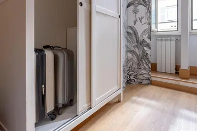 a room with a door with a suitcase and a window at New Unico San Cosimato in Rome
