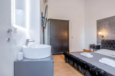 a bathroom with a sink and a bed at New Unico San Cosimato in Rome