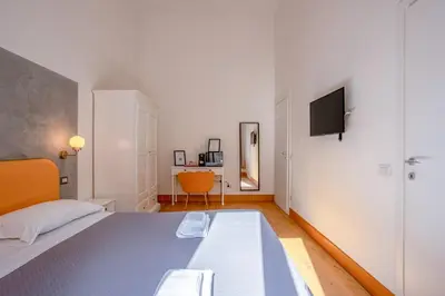 a bedroom with a bed and a tv on a wall at New Unico San Cosimato in Rome
