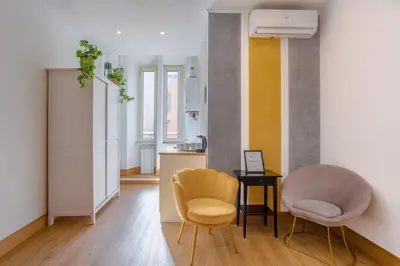 a living room with two chairs and a table at New Unico San Cosimato in Rome