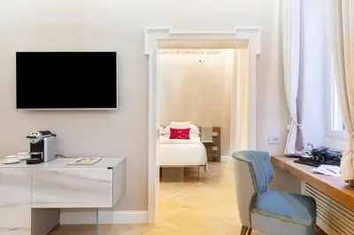 a room with a desk and a television on a wall at Poēsis Experience Hotel in Rome