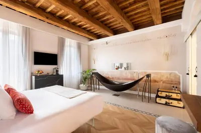a bedroom with a bed and a swing chair at Poēsis Experience Hotel in Rome