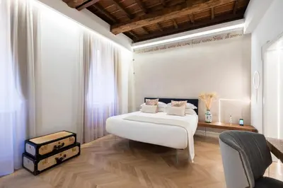 a bedroom with a large white bed and a chair at Poēsis Experience Hotel in Rome