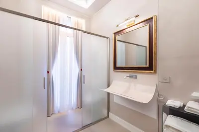 a bathroom with a shower and a sink and a mirror at Poēsis Experience Hotel in Rome