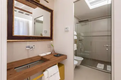 a bathroom with a mirror and a toilet at Poēsis Experience Hotel in Rome