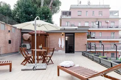 a patio with an umbrella and a table and chairs at La Suite al Vaticano in Rome