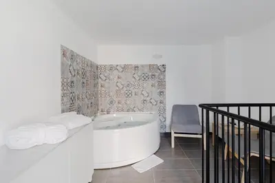 a bathroom with a bath tub and a chair at La Suite al Vaticano in Rome