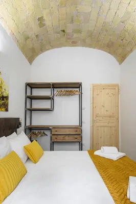 a bedroom with a white bed and a wooden door at Industrial-Style Apartment Next To Vatican Metro in Rome