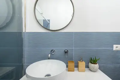 a bathroom with a white sink and a mirror at Industrial-Style Apartment Next To Vatican Metro in Rome