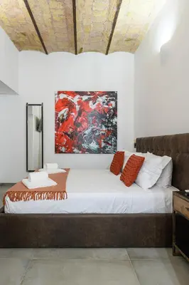 a bed in a room with a painting on the wall at Industrial-Style Apartment Next To Vatican Metro in Rome