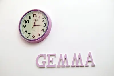 a clock on a wall next to a gma sign at GEMMA DOMUS in Rome