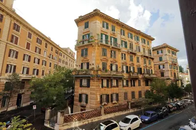 a tall building with cars parked in front of it at GEMMA DOMUS in Rome
