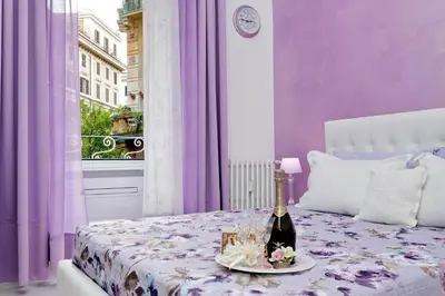 a purple bedroom with a bottle of wine on a bed at GEMMA DOMUS in Rome
