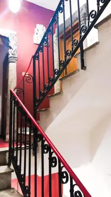 a staircase with red and black railings in a building at Romantico appartamento a Trastevere in Rome