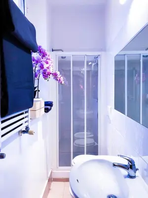 a white bathroom with a sink and a glass shower at Romantico appartamento a Trastevere in Rome