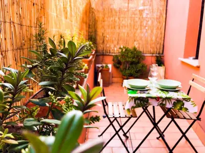 a table and chairs in a room with plants at Romantico appartamento a Trastevere in Rome